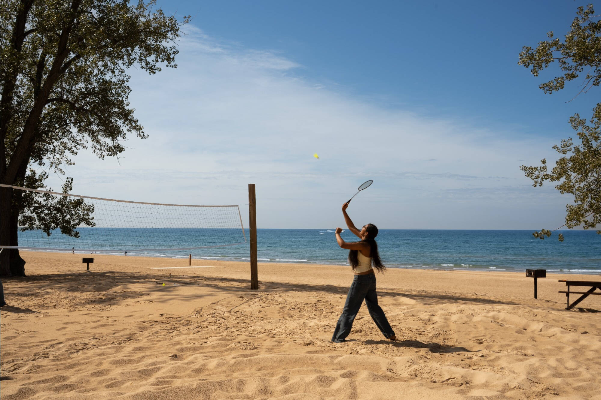 A girl playing badminton on the beach
